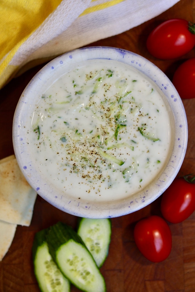 vegan tzatziki in a serving bowl surrounded by veggies