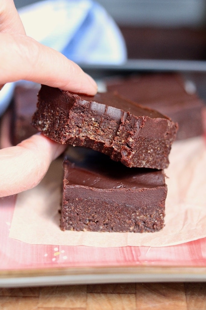 raw vegan brownie with a bite missing being picked up