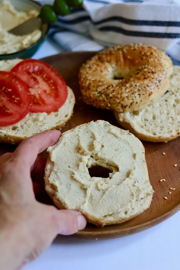 cream cheese bagel being taken off a plate
