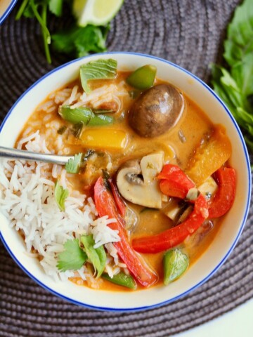 vegan thai red curry vegetables Iin a white bowl with rice