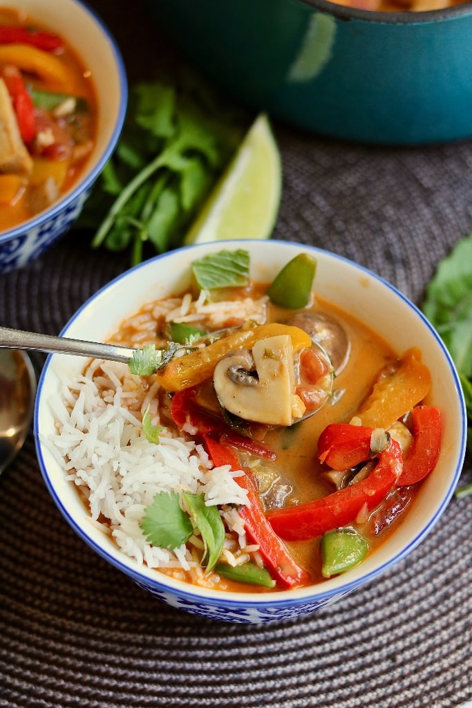thai red curry with vegetables and rice in a bowl with a spoon