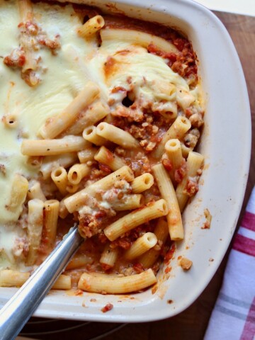 vegan baked ziti in a casserole dish with serving spoon