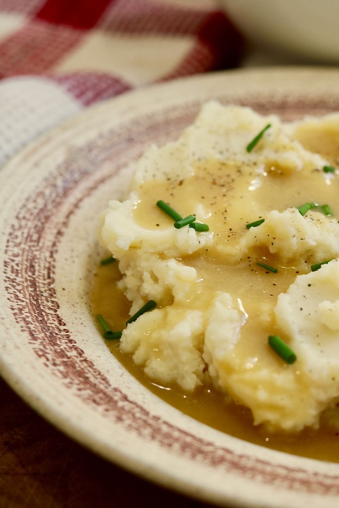 close up view of vegan gravy over mashed potatoes on a plate 