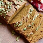 four slices of vegan pumpkin bread on a cutting board