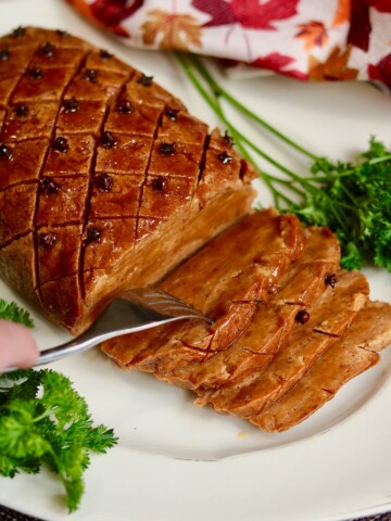 vegan ham roast on a platter sliced