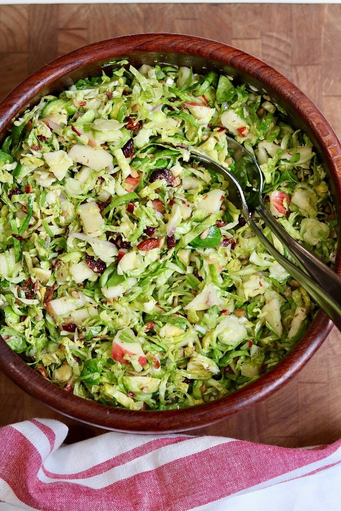 brussels sprout salad in a bowl with serving spoons