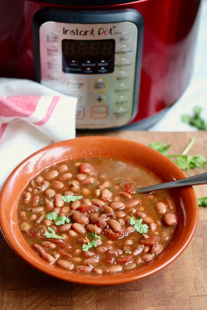 charro beans in a bowl beside an instant pot