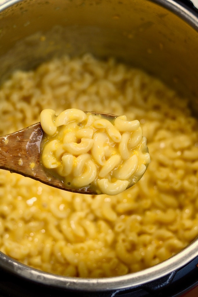 mac and cheese being scooped out of an instant pot