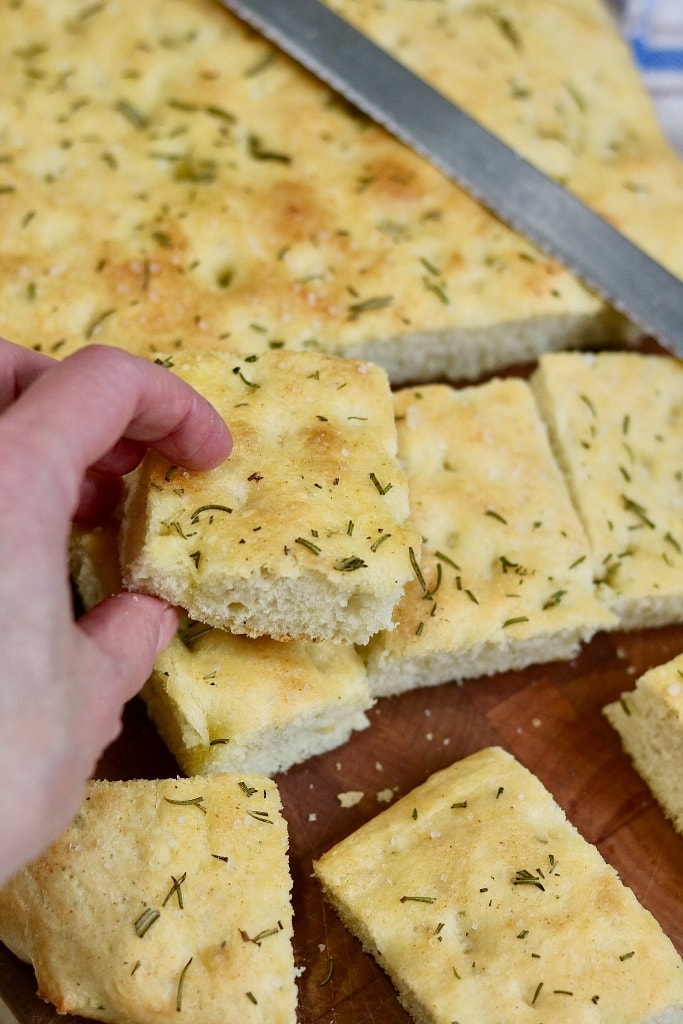 focaccia bread cut into squares on cutting board
