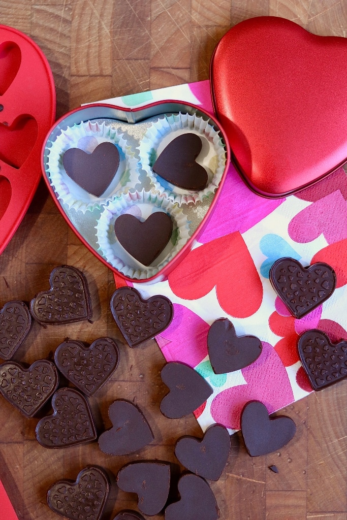 dairy free chocolates unmolded on table beside chocolate heart valentine tin 