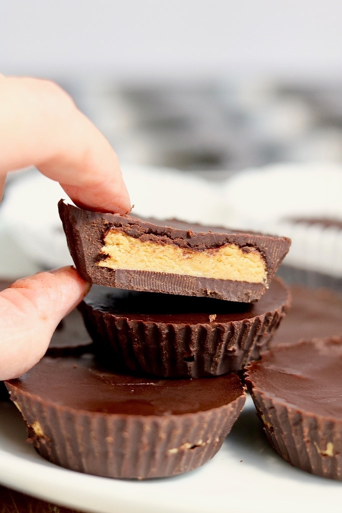 vegan peanut butter cups stacked on plate one cut in half