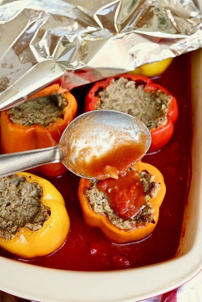 stuffed pepper being topped with tomato sauce