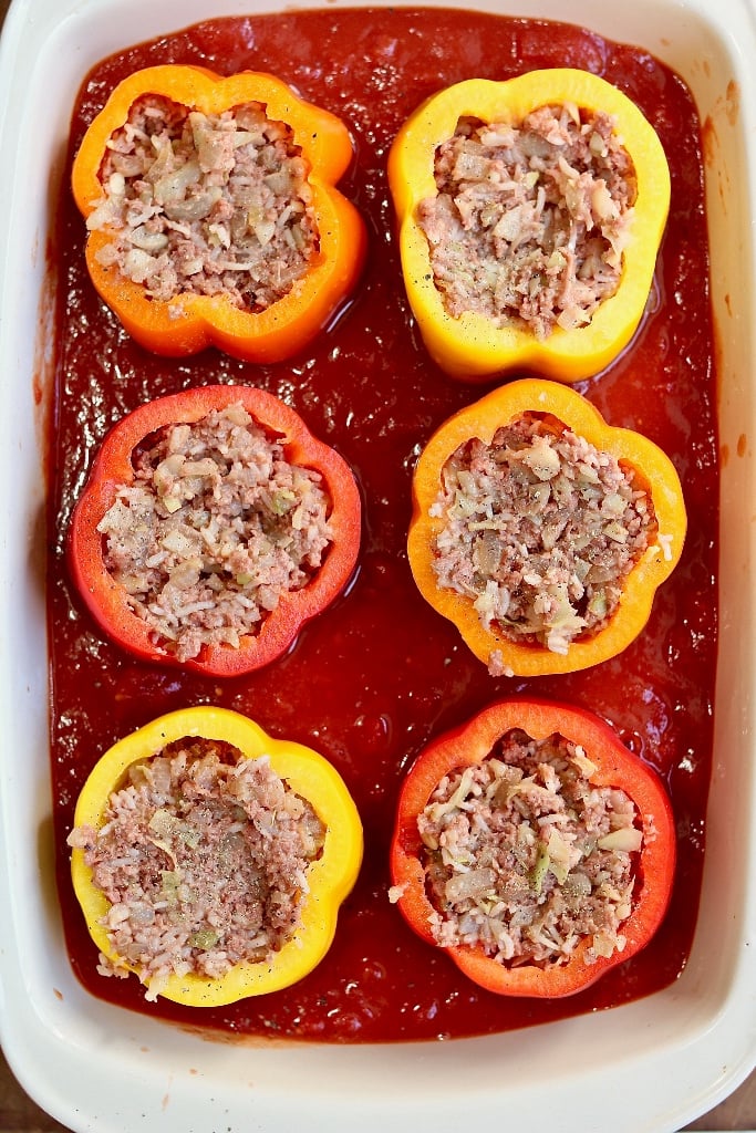 peppers being stuffed with vegan meat filling