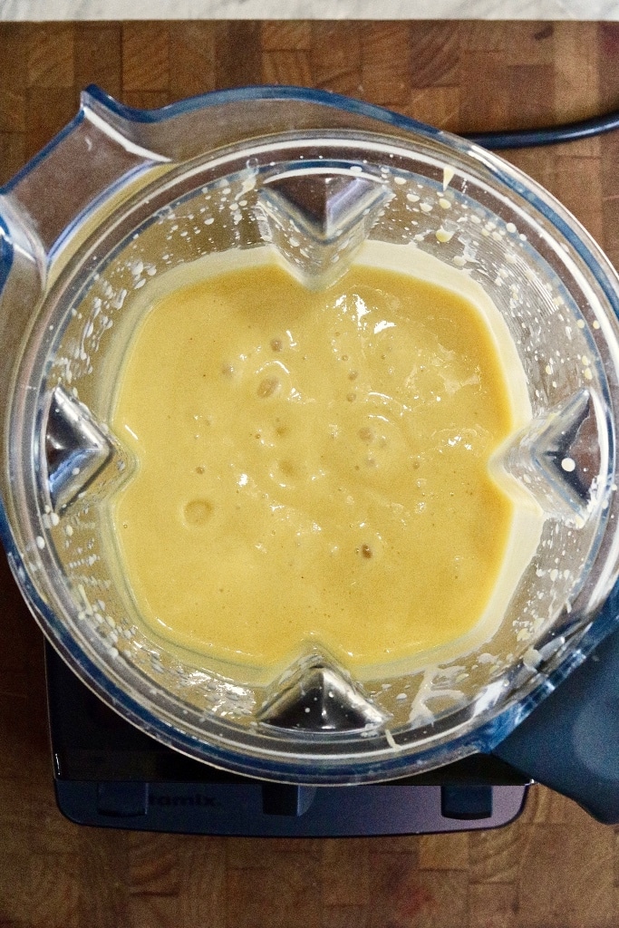 overhead photo mango smoothie being made in a blender 