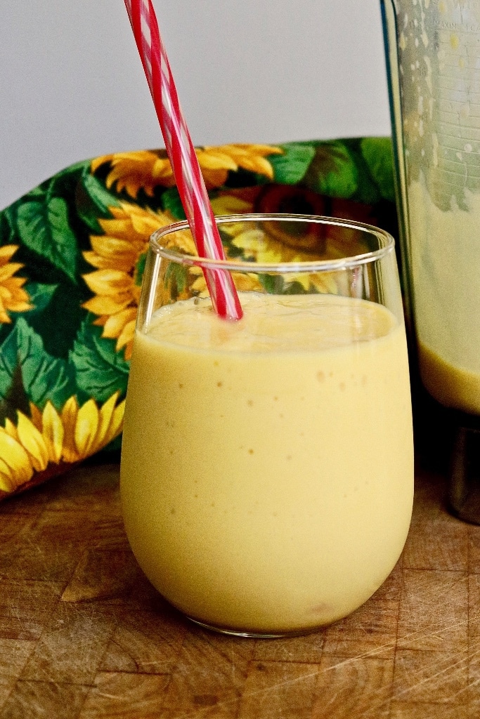 mango smoothie ready to serve in a glass with straw