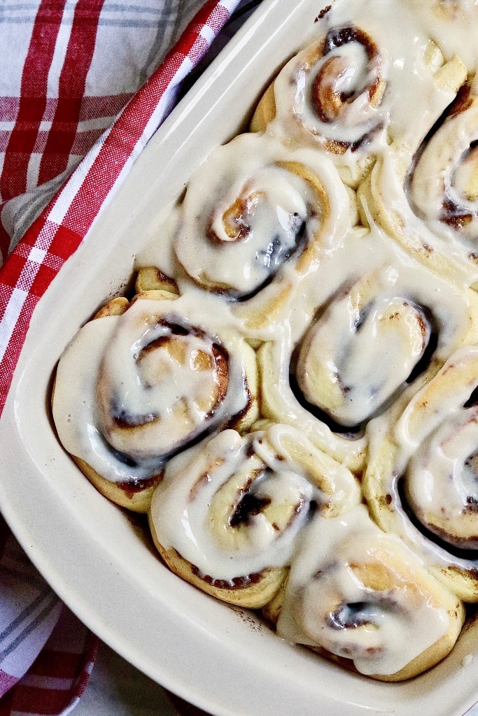 vegan cinnamon rolls in a baking dish with frosting