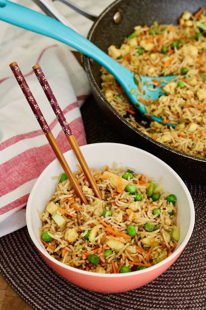 side view vegan fried rice in a bowl with chopsticks 