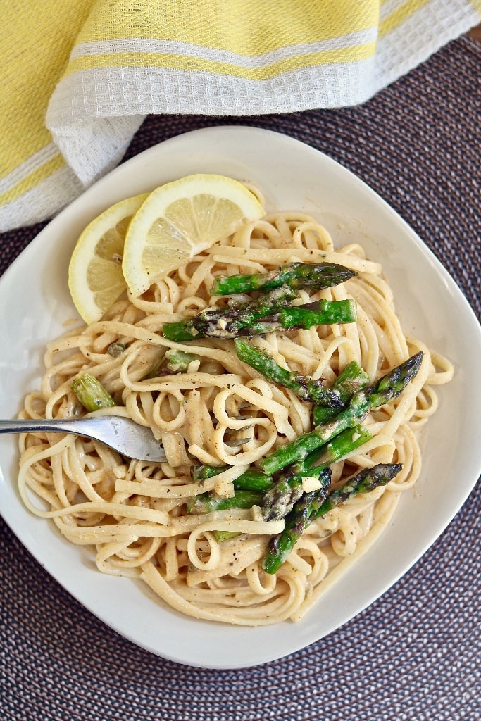 lemon pasta on a plate topped with asparagus and garlic