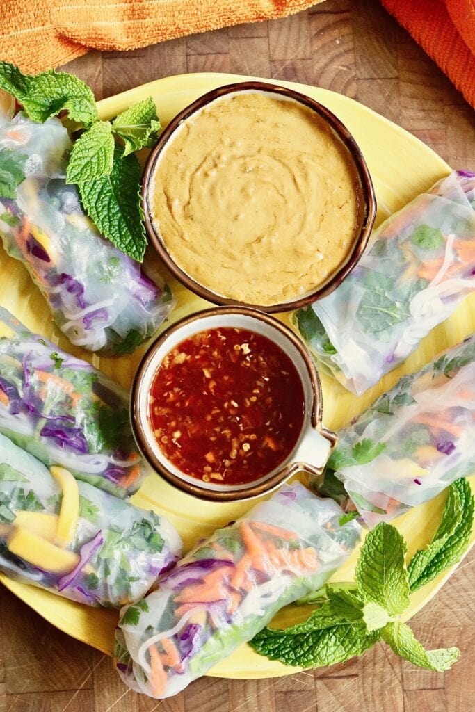 vietnamese dipping sauce on  a plate with peanut sauce and fresh spring rolls