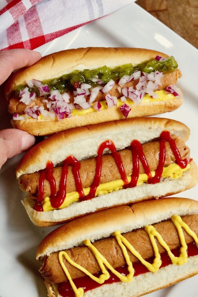 vegan hot dogs in buns with various toppings