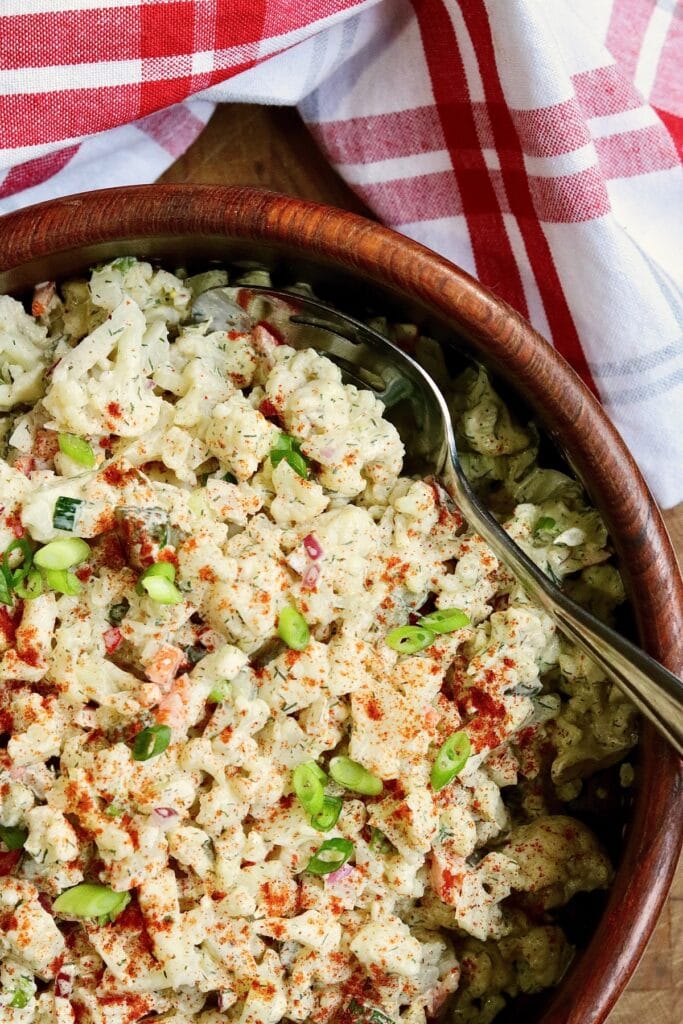 cauliflower salad in a bowl tossed with vegan dressing