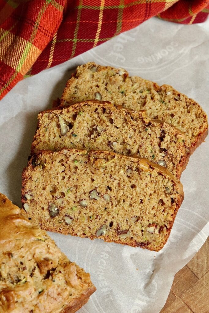 three slices of vegan zucchini bread on cutting board