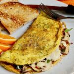 just egg omelette on a white plate with toast and orange slices ready to eat