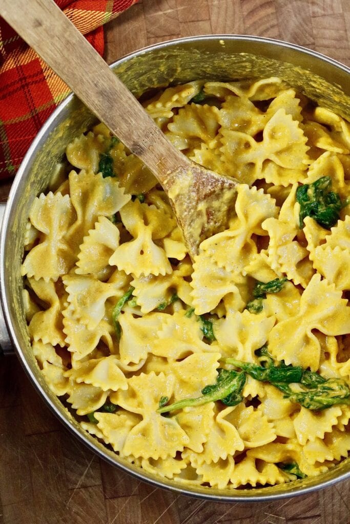 bowtie pasta in a pot tossed with vegan pumpkin pasta sauce 