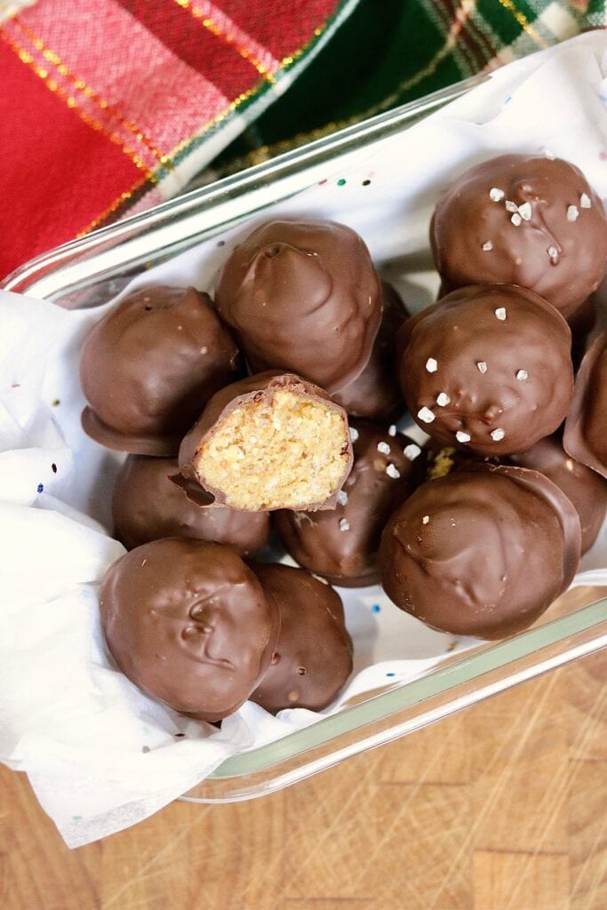 chocolate peanut butter balls in a holiday container ready to serve 