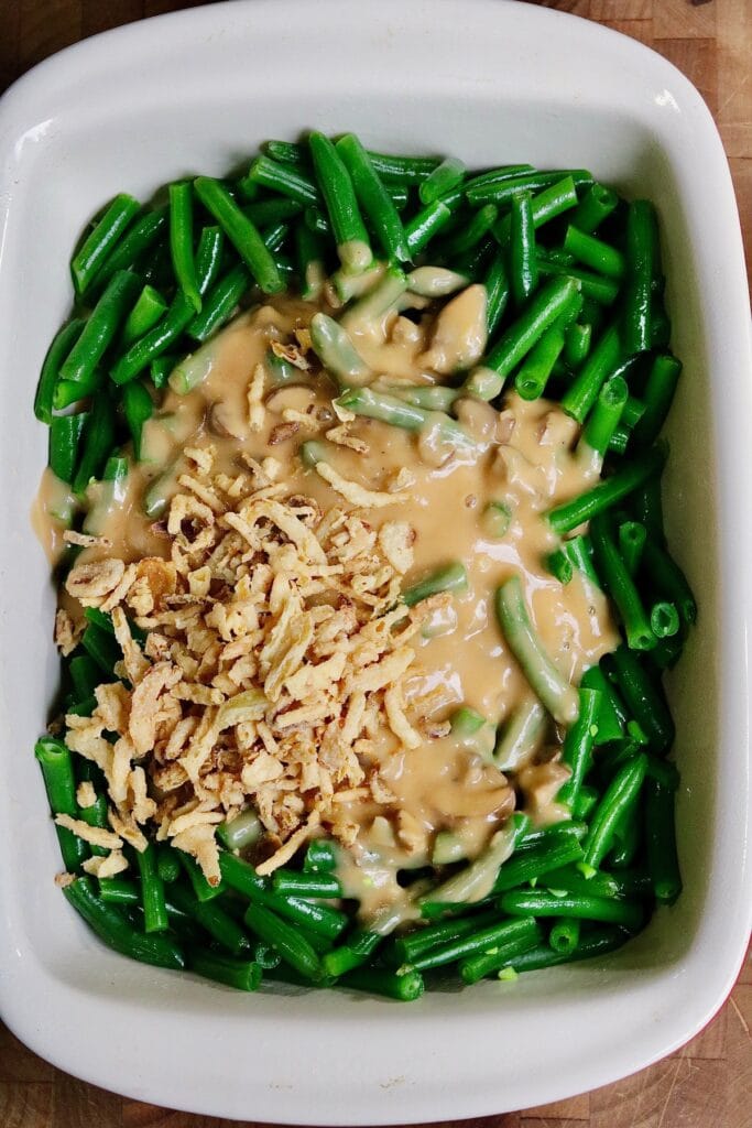 green bean casserole ingredients in a dish ready to toss and bake