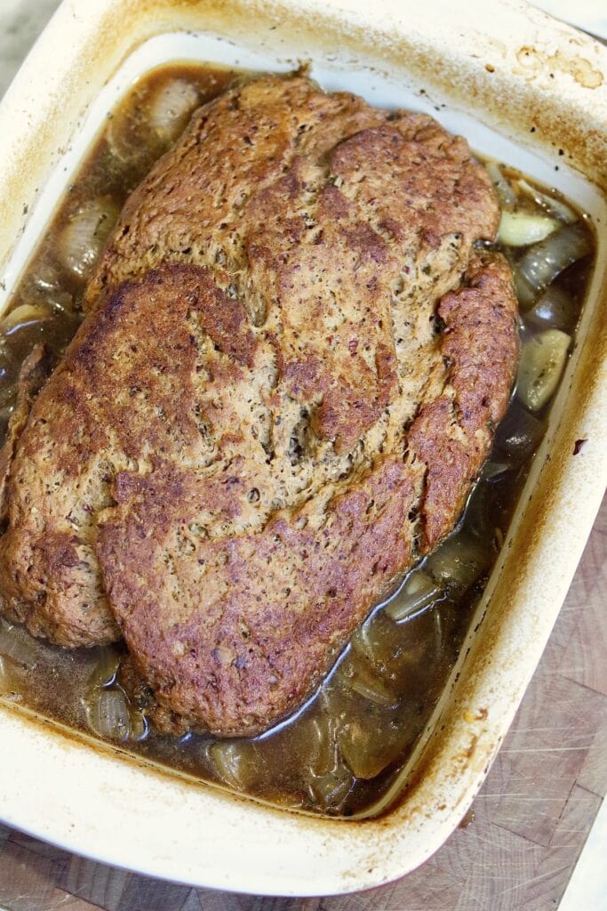 whole seitan beef roast baked in a casserole dish 