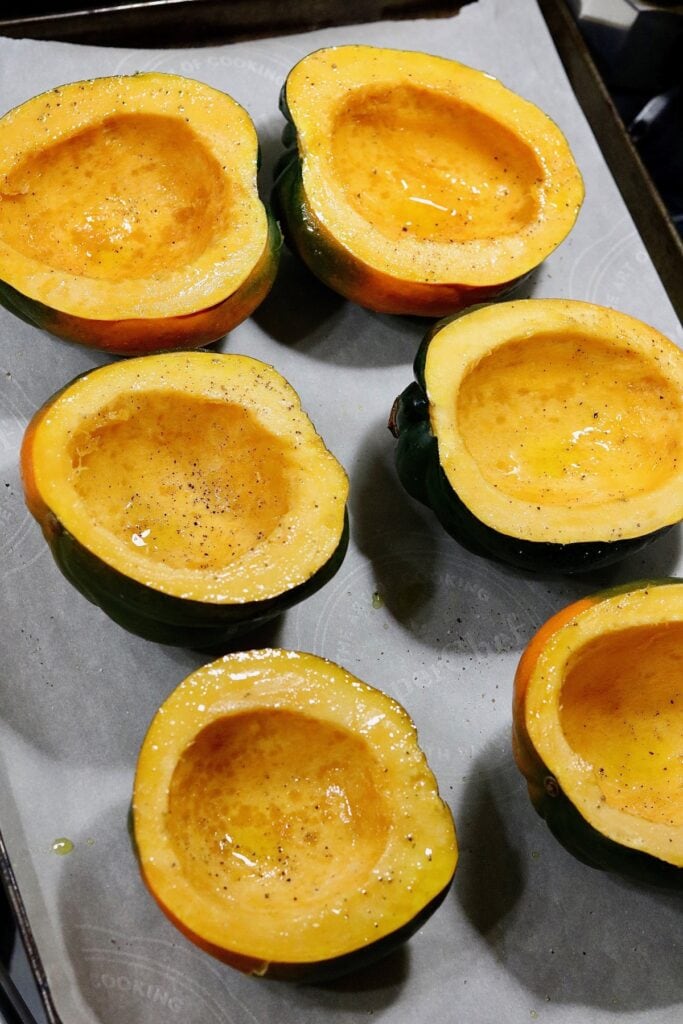 3 acorn squash cut in half and seeded on a baking sheet