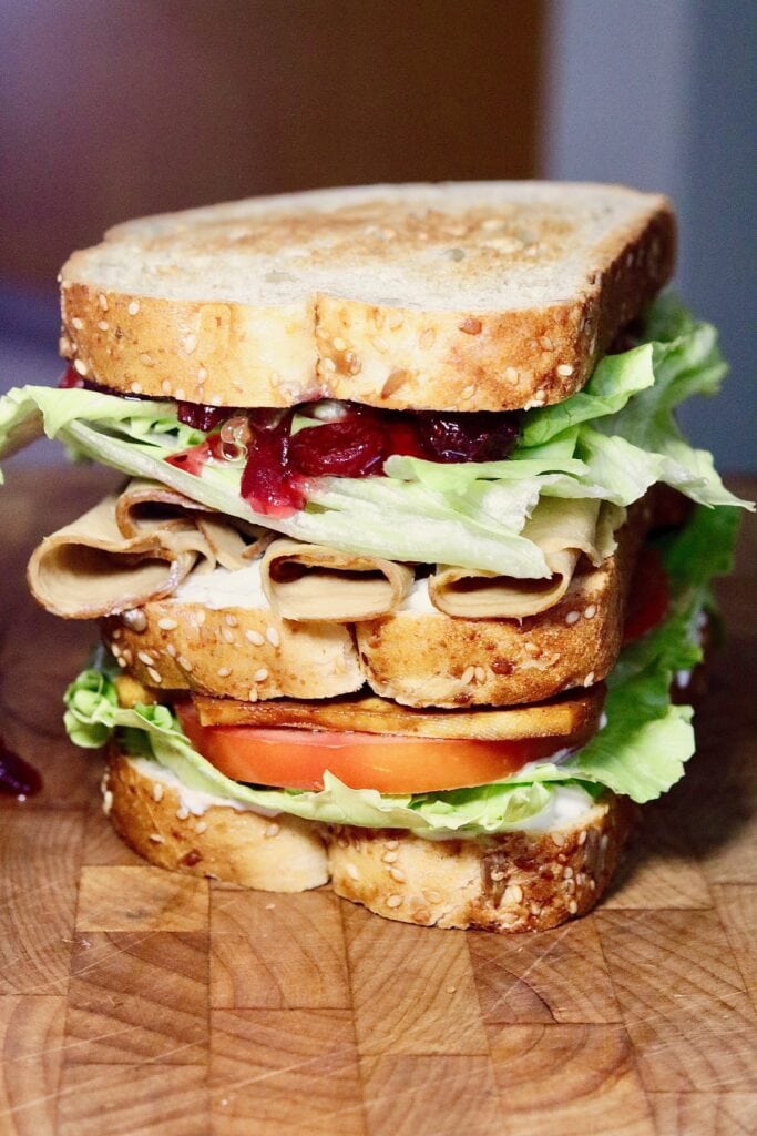 a close up of a vegan club sandwich and all the filling ingredients