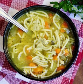 a bowl of vegan chicken noodle soup with a spoon