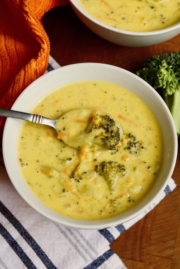 a bowl of vegan broccoli cheddar soup on a table