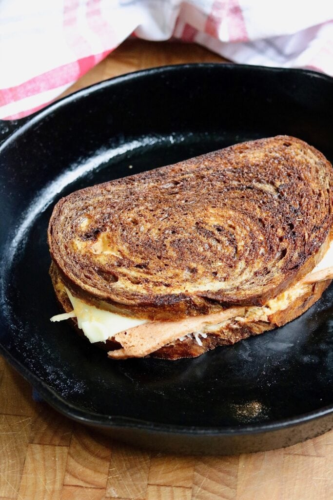 a vegan reuben sandwich grilled in a pan 
