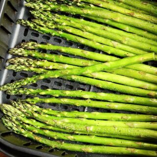 asparagus spears cooked in an air fryer basket