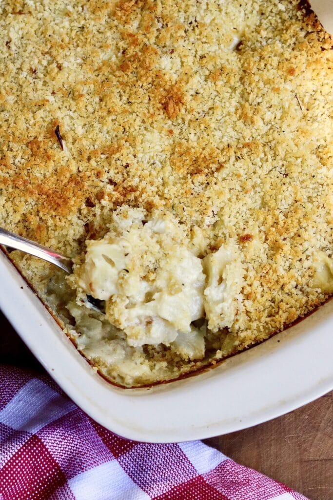 cauliflower casserole being served from a baking dish