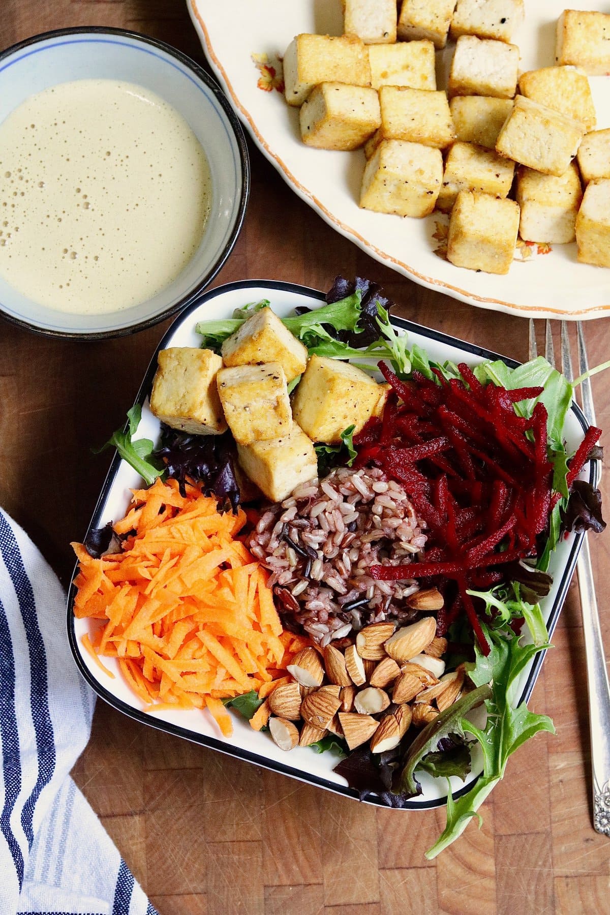 glory bowl salad in a bowl with tahini dressing on the side