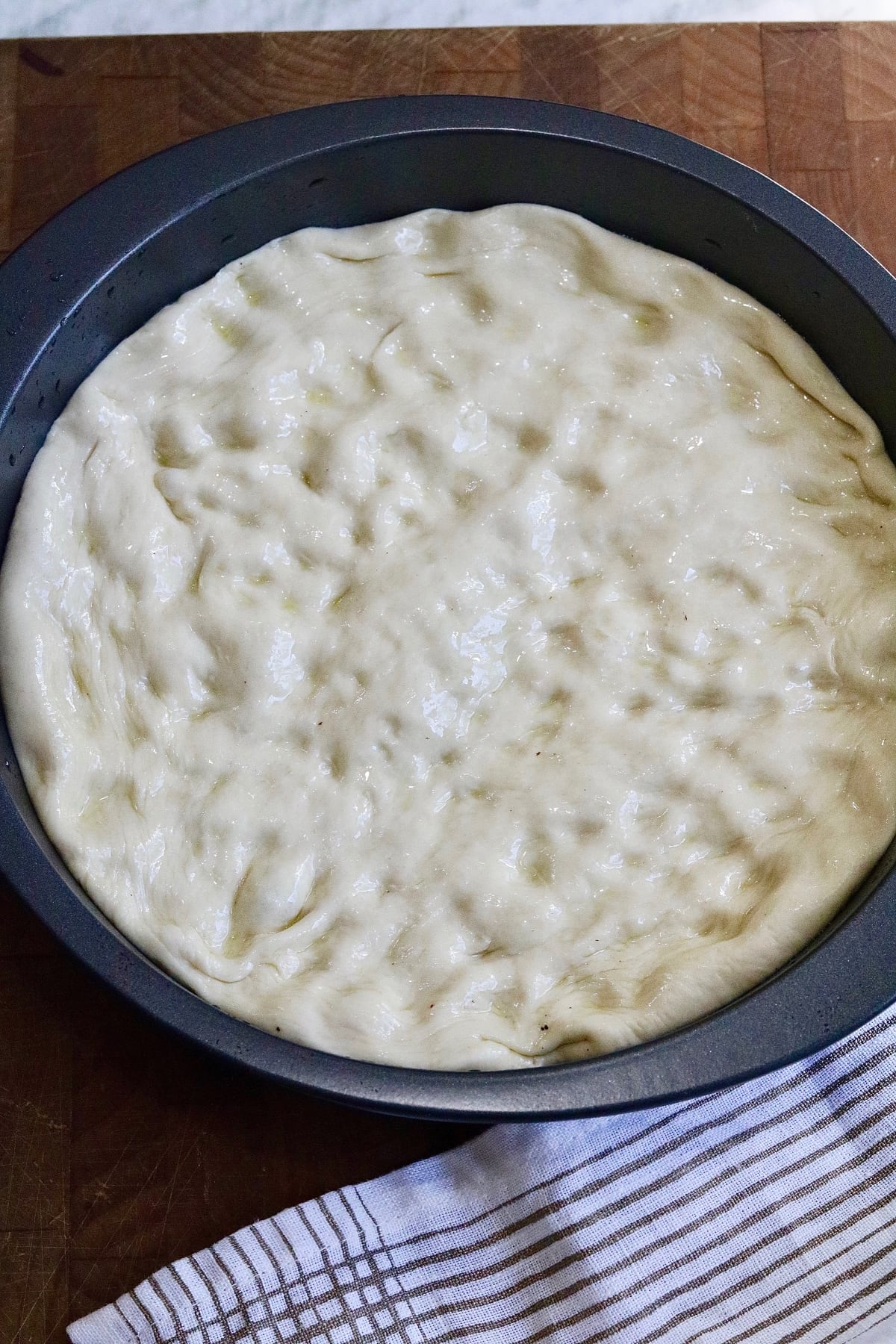 pizza dough spread into a pizza pan ready to be topped