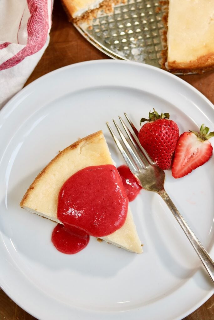 a slice of New York style vegan cheesecake on a plate with a fork