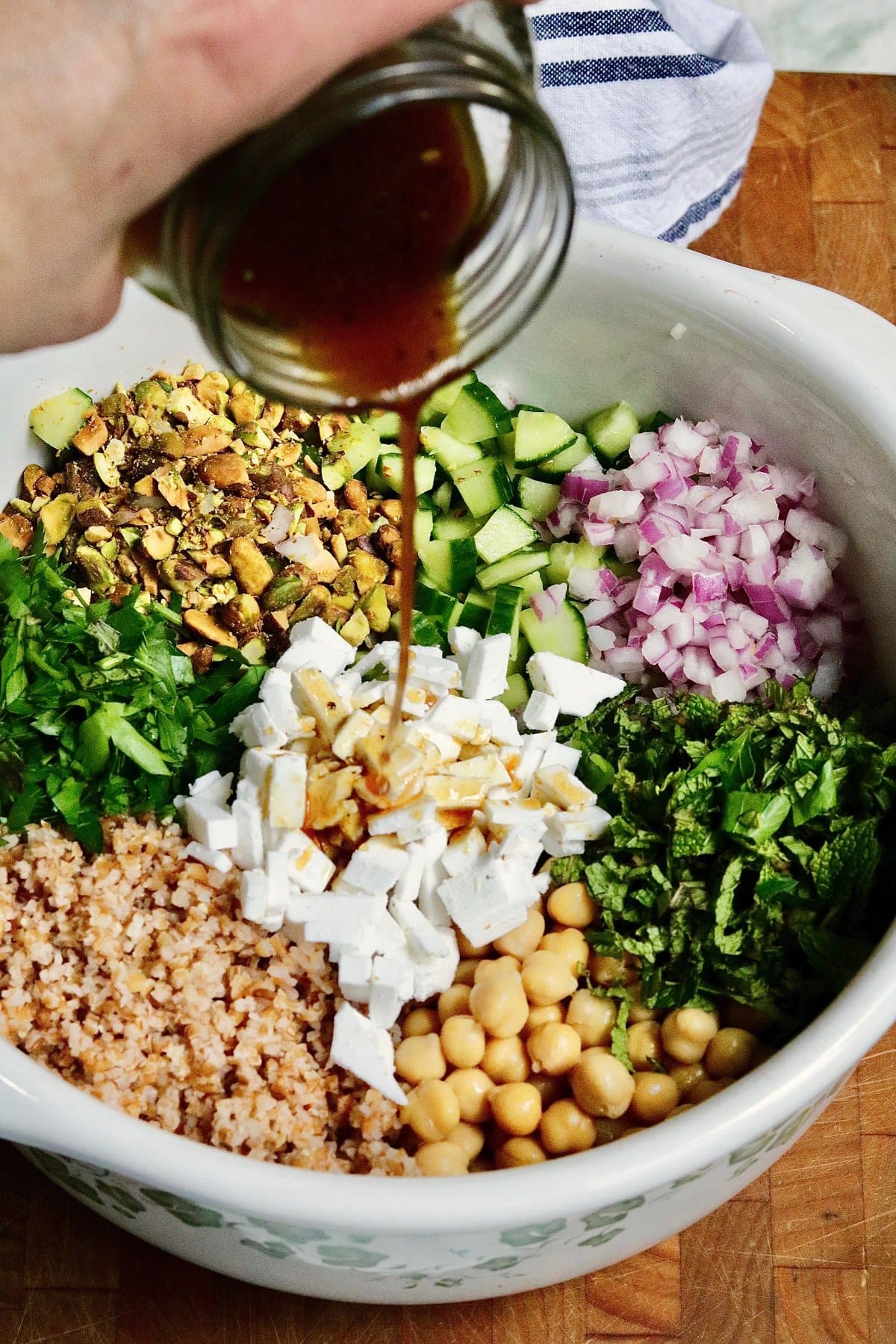 dressing being poured over Jennifer Aniston salad