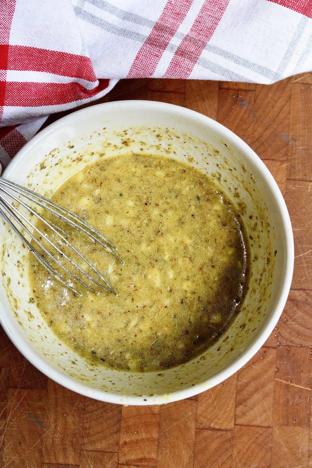 greek marinade ingredients whisked in a bowl ready for tofu cubes