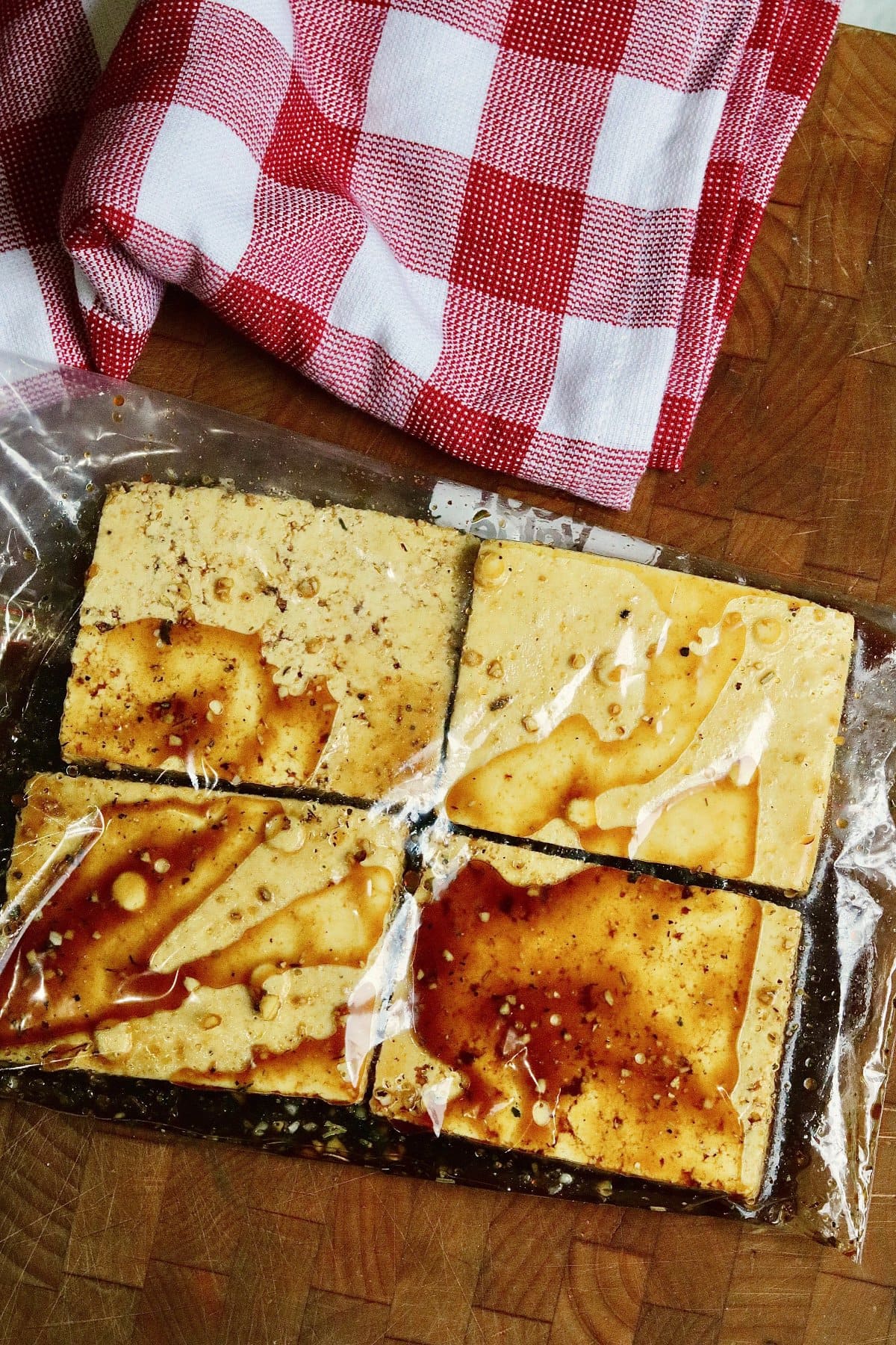 slabs of tofu marinating in vegan steak marinade in a ziplock bag 