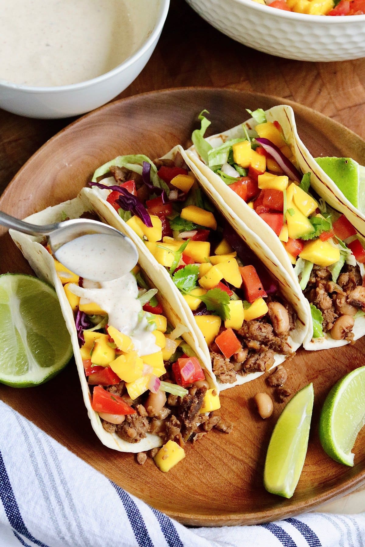 vegan jerk tacos on a plate with lime wedges