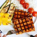 grilled bbq tofu on a plate with veggie skewers and rice