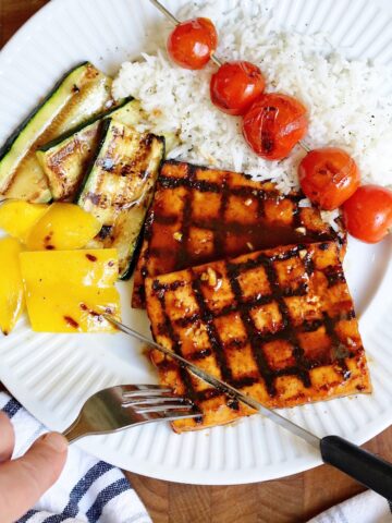 grilled bbq tofu on a plate with veggie skewers and rice