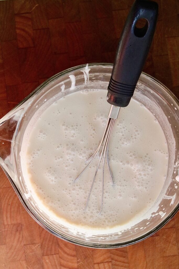 ingredients for vegan vanilla ice cream whisked in a glass bowl
