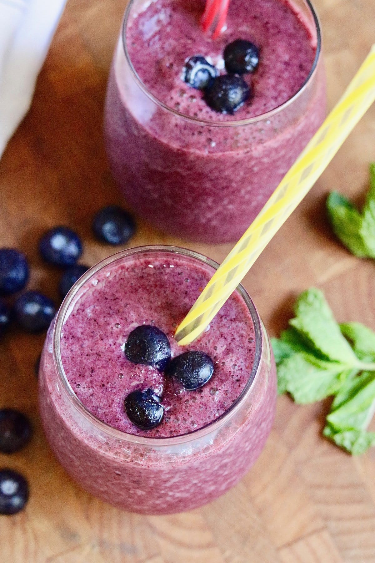 blueberry banana smoothie in a drinking glass with a straw