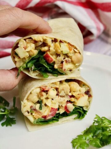 curried chickpea salad wrap sliced in half on a plate